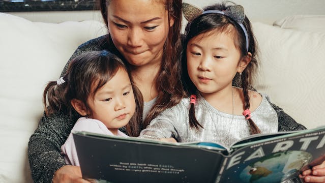 Photo by Kindel Media: https://www.pexels.com/photo/a-mother-and-her-kids-reading-a-book-7105615/